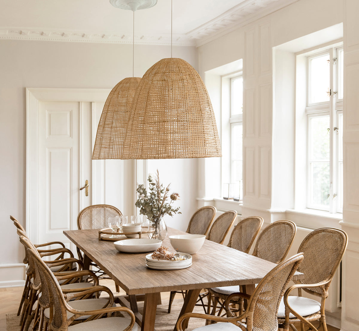 This is a lifestyle image of Showroom Lampshade in natural core weave artfibre & aluminium. Hanging over a set dining table in a bright room.