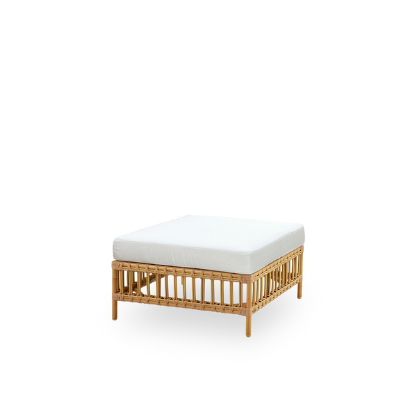 Side view of Maggie outdoor sofa pouf module in Natural color presented with glass top to be used as side table. Aluminium frame with handpainted rattan look with ArtFibre windings.
